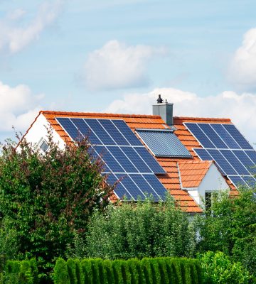 Modern house with photovoltaic solar cells on the roof and a thermal solar heating system for alternative energy production